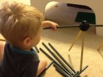 Two year old using his fine motor skills to put the pole into the connector